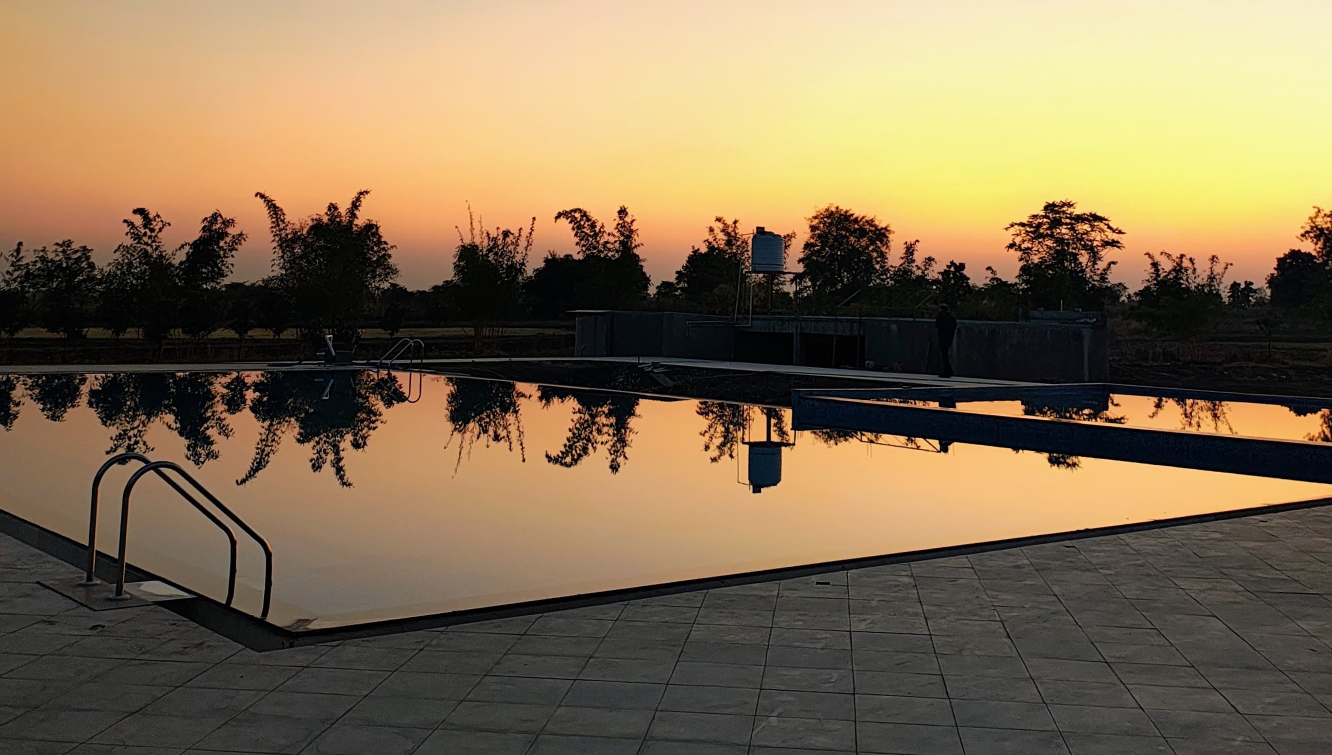 Sunset over a pool with reflections of trees