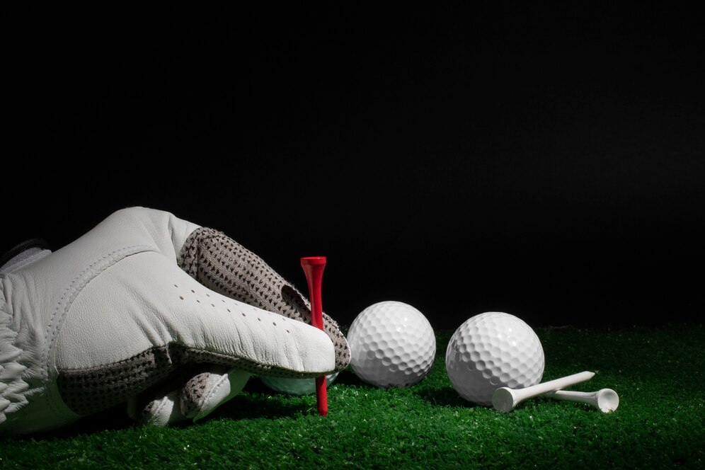 Close-up of a gloved hand placing a golf ball on a tee.